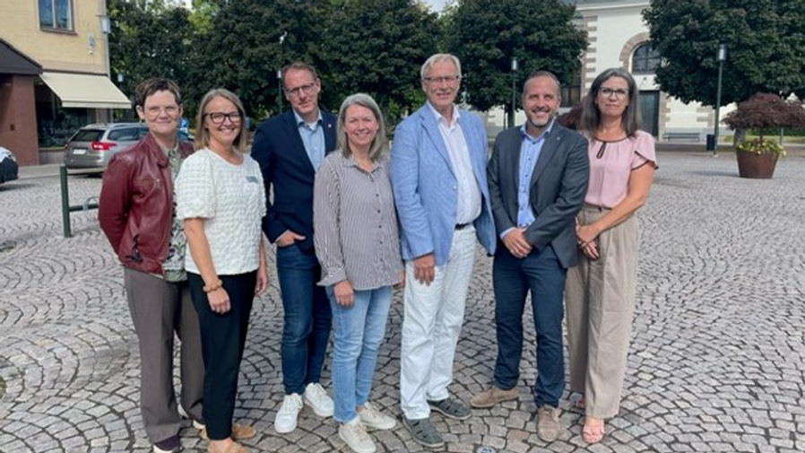 Eva Ulfenborg och Klara De Boer (Hjo), Gustav Olofsson och Frida Blomqvist (Tibro), Mats Porsklev (Sydarkivera), Johan Myhrman och Sandra Peters (Karlsborg) står på ett torg och ler in i kameran.