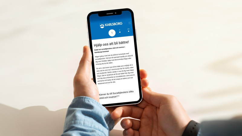 En person som håller en mobiltelefon i handen.