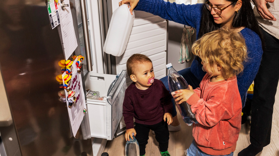 Familj som lägger vattenflaskor i frysen för att kunna använda vid vattenbrist.