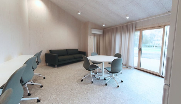 Ett rum med en soffa, ett bord och stolar.