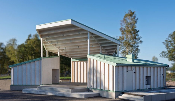 En vit byggnad med grönt tak och trappor.