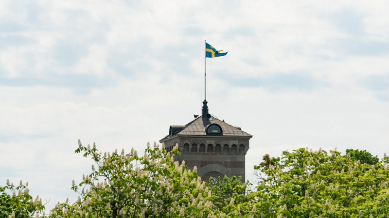 Toppen av kyrktornet på Karlsborgs fästning som flaggar med svensk flagg.