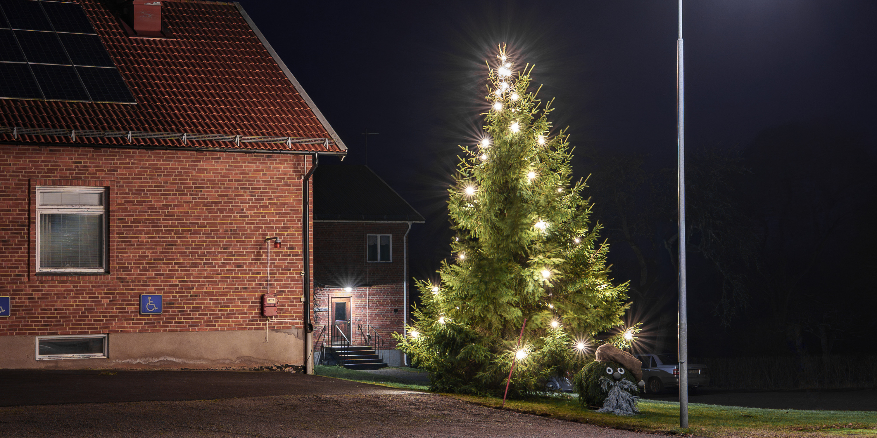 Julgran och tomte bredvid tegelbyggnad