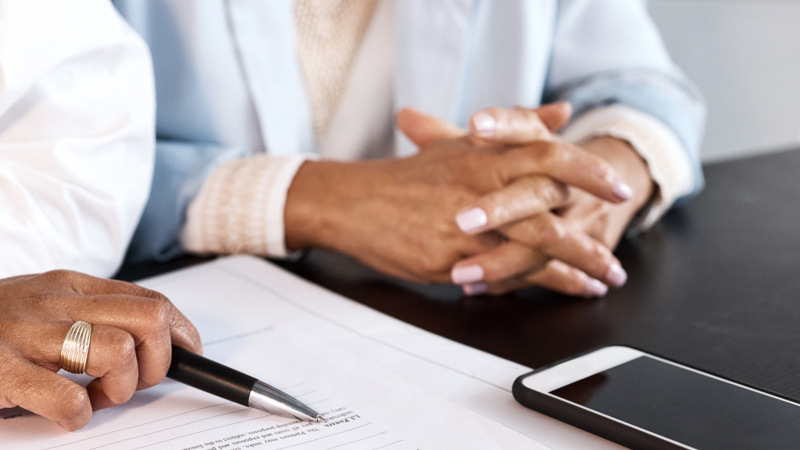 Några personer som sitter vid ett bord med papper.