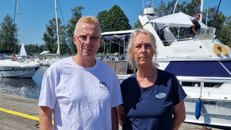 Kommunchef Kajsa Eriksson Larsson och turistchef Jarl Karlsson står bredvid varandra på en brygga med en båt i bakgrunden.