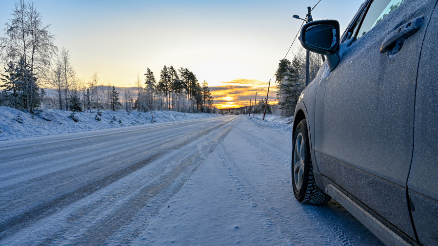 En bil som står still på en snöig väg.