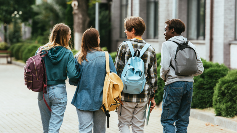 En grupp unga människor som går på en trottoar