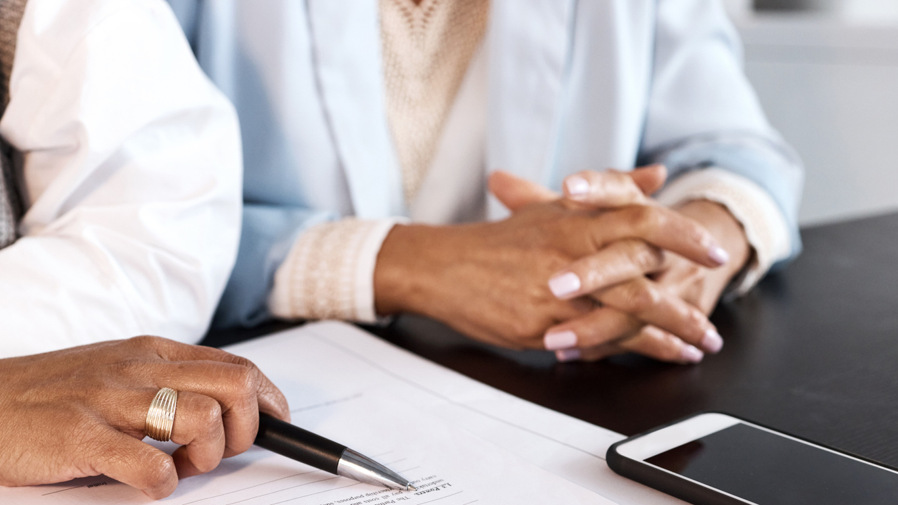 Några personer som sitter vid ett bord med papper.